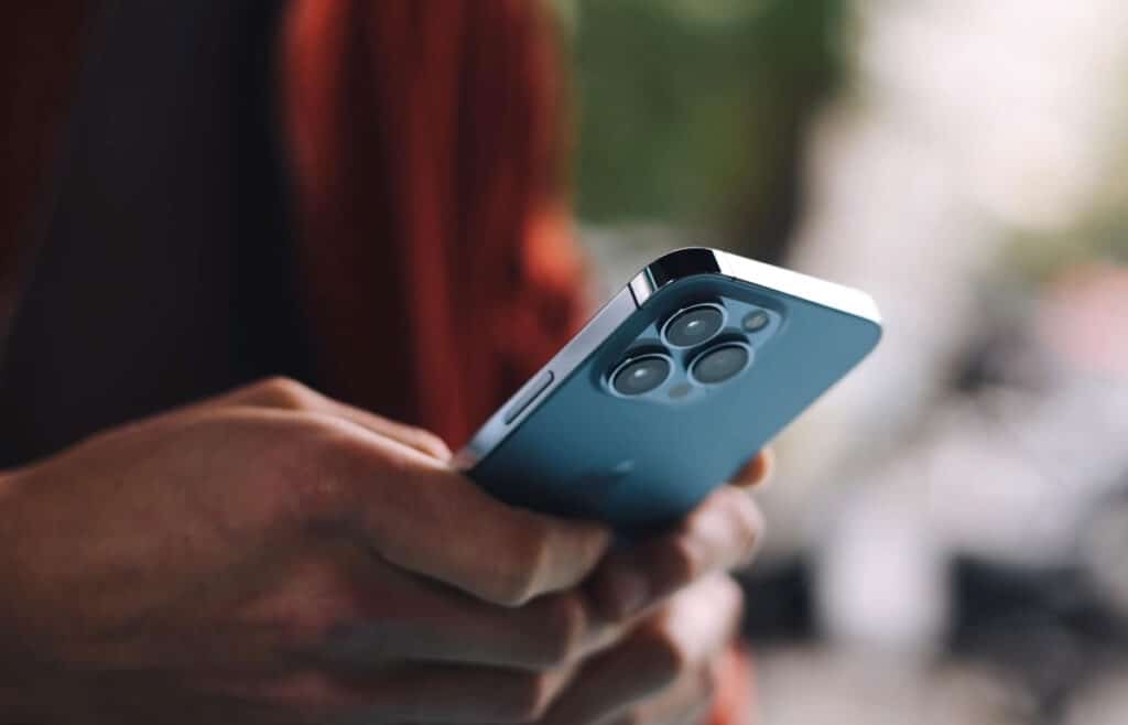 Close up of a mans hands using an iPhone.