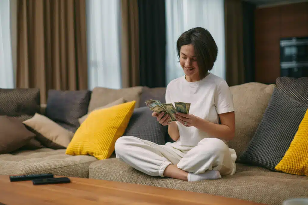 Happy young woman counting cash.