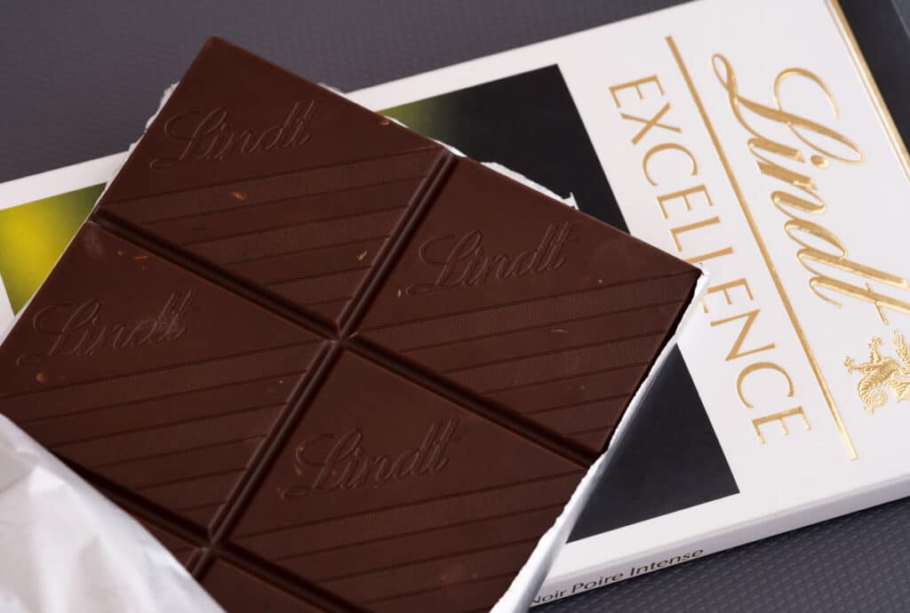 Lindt Excellence Intense Pear chocolate bar with its pack on gray background.