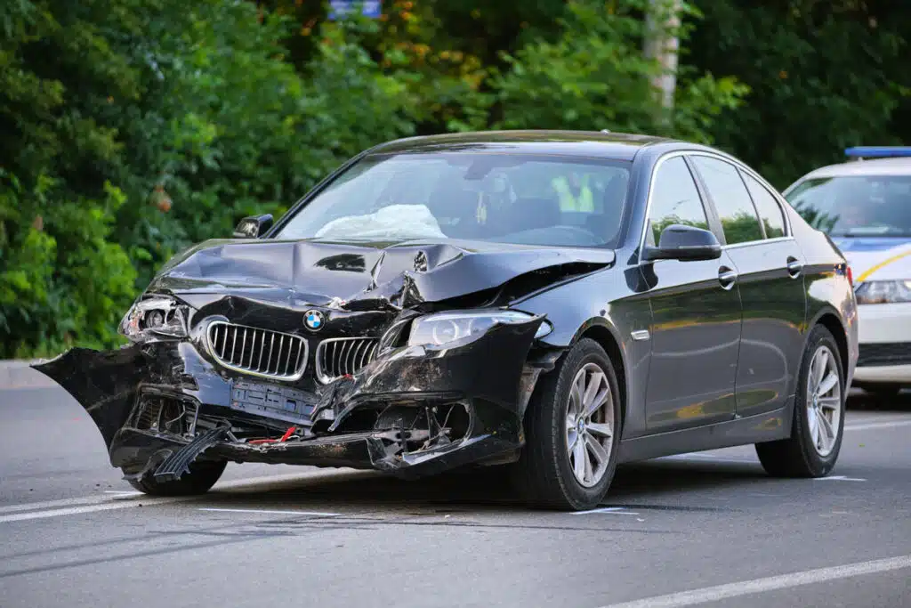 Black vehicle with damage on the front bumper, representing the American Family insurance total loss class action settlement.