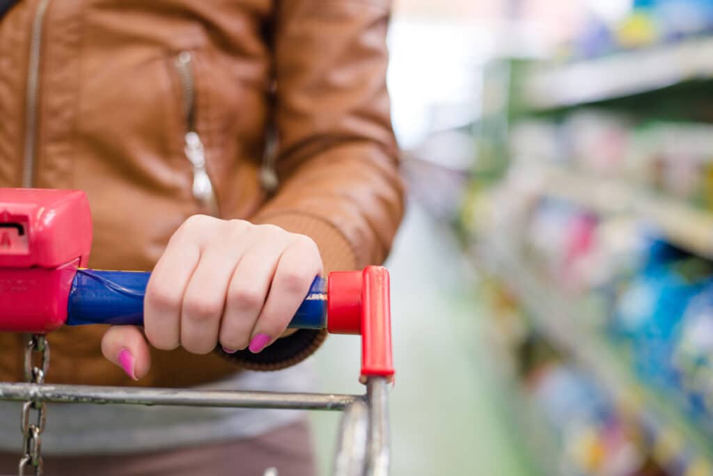 Close up of a womans hands on a shopping cart.