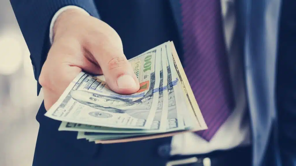 Busness man handing over cash representing refund