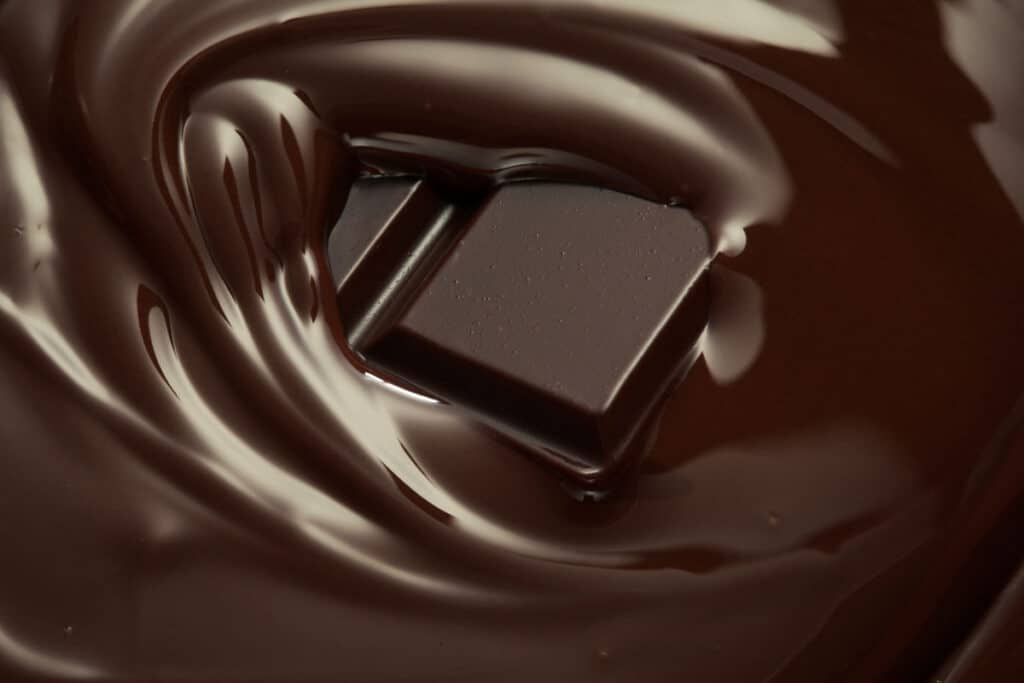 Close up of melted chocolate surrounding a piece of chocolate.
