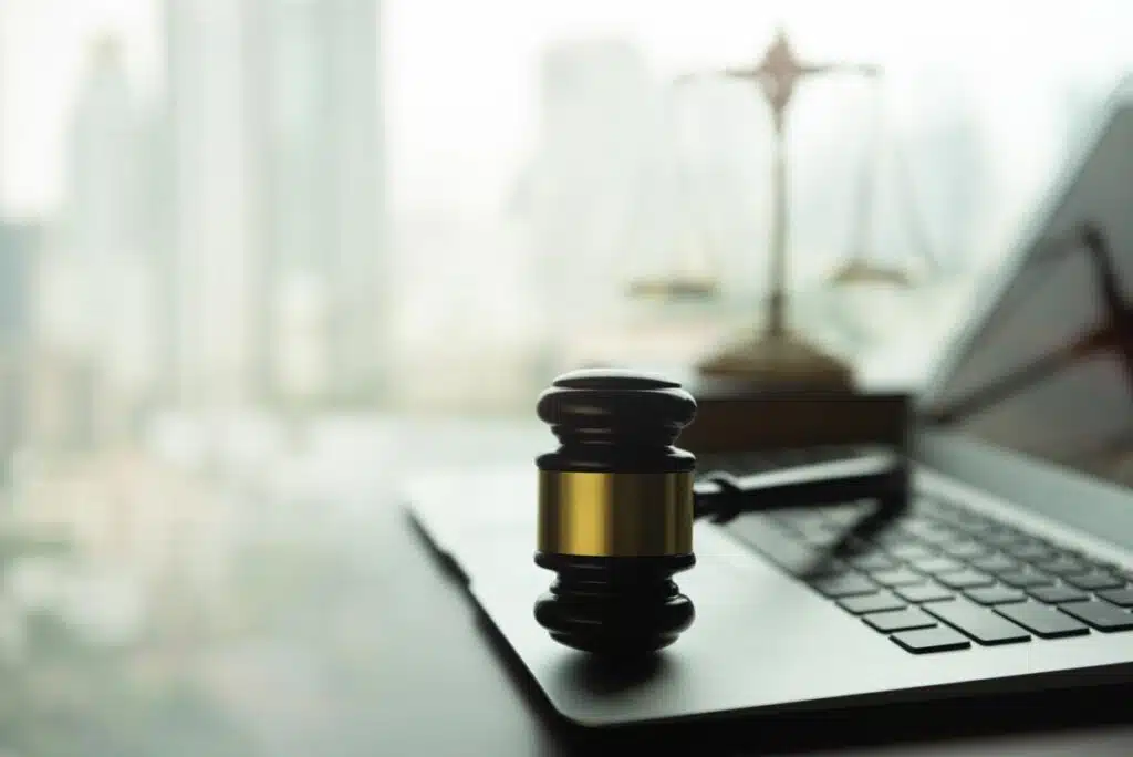 Close up of a judges gavel resting on a laptop.