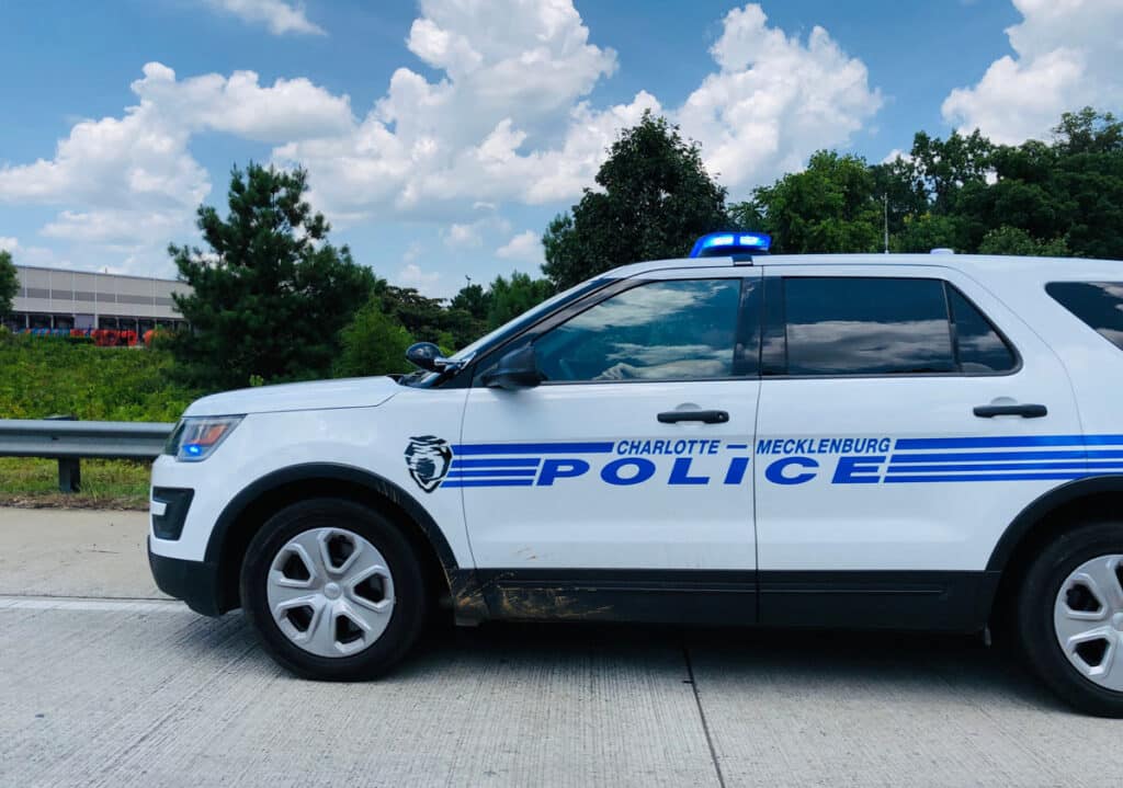 Charlotte Mecklenburg Police car on the side of highway, representing the Charlotte-Mecklenburg Volunteer Police Pledge Fund settlement.