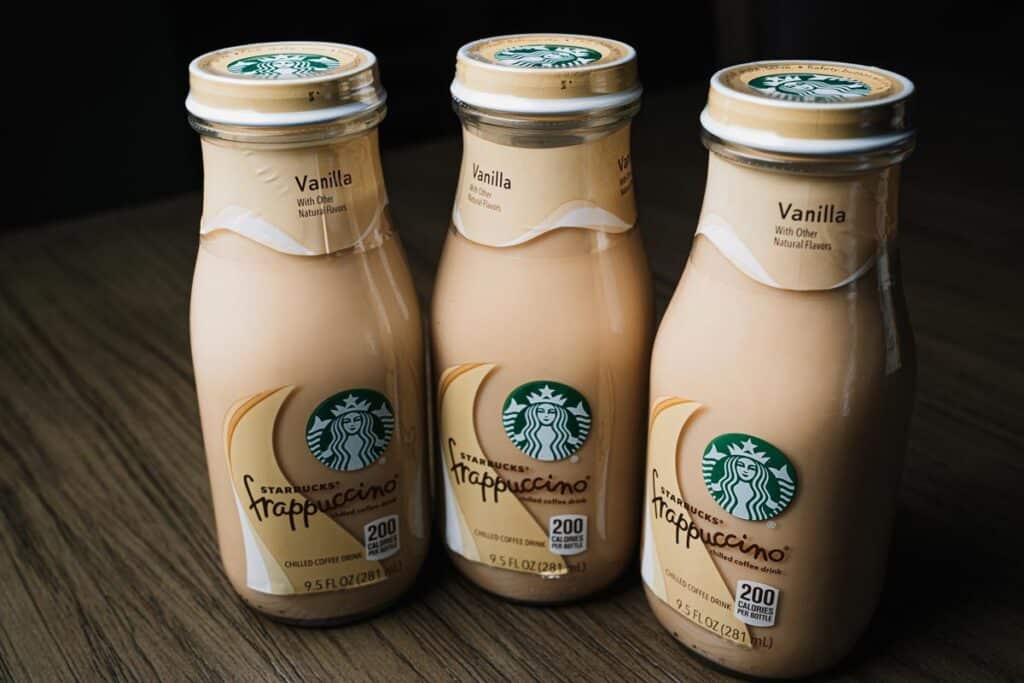 Close-up of multiple Starbucks frappuccino drinks on top of a wooden table.