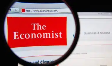 Photo of The Economist homepage on a monitor screen through a magnifying glass, representing the Economist Michigan class action settlement.