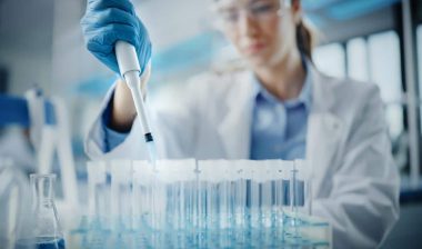 Female Scientist in Goggles Using Micro Pipette for Test Analysis, representing the Massachusetts drug conviction settlement.