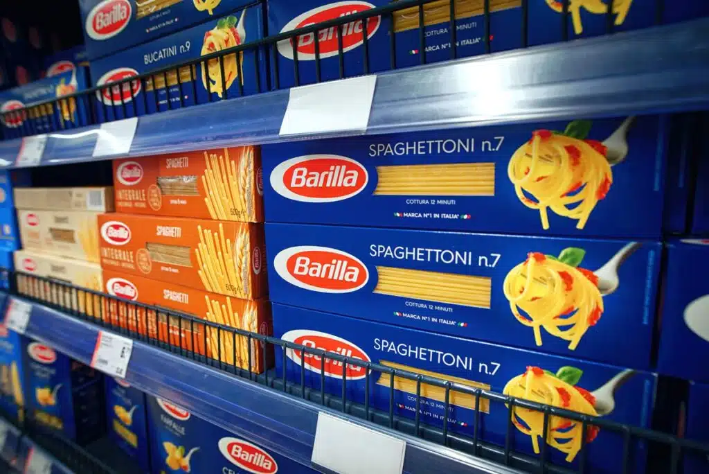 Barilla pasta boxes for sale on a grocery store shelf.