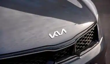 KIA Motors new angular logo on hood of dark grey Kia vehicle.