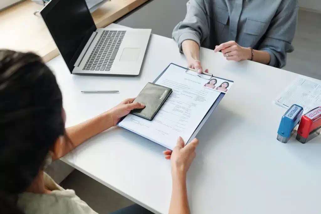Close up of a woman holding a clipboard with a VISA application.