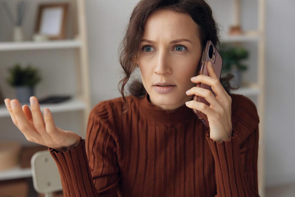 Irritated woman talking on the phone, representing the National Do Not Call Registry class action lawsuit dismissal.