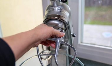 View of a female's hand putting a paddle attachment on a Kitchenaid stand mixer.