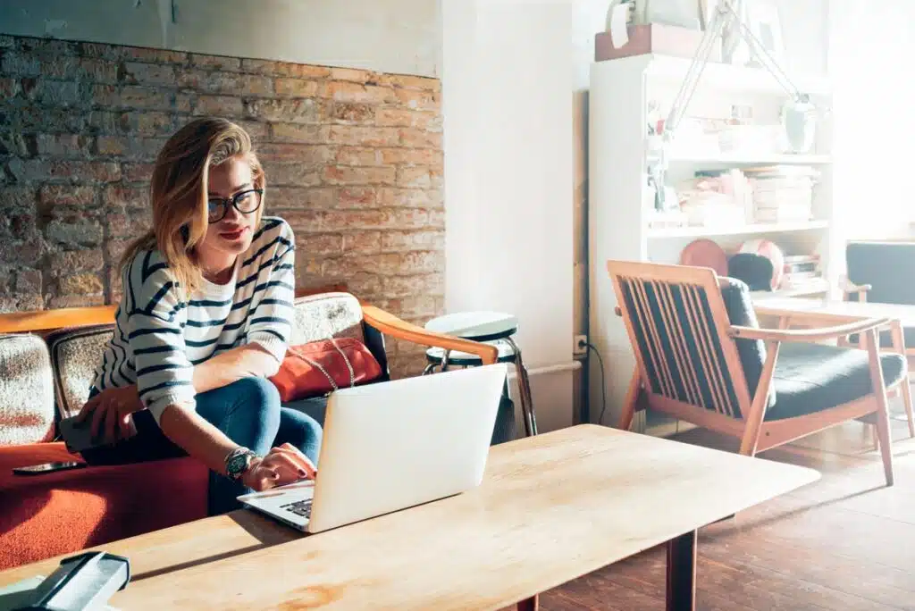 Beautiful young blonde female student using portable laptop computer while sitting in a vintage coffee shop, representing the People and Entertainment Weekly class action lawsuits.