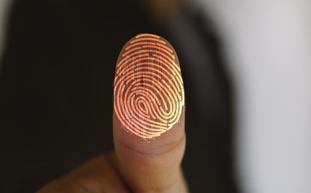Close up of a thumb pushed against a lens with a fingerprint overlay.