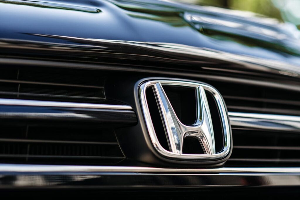 Honda motor company badge on the from of a black car.