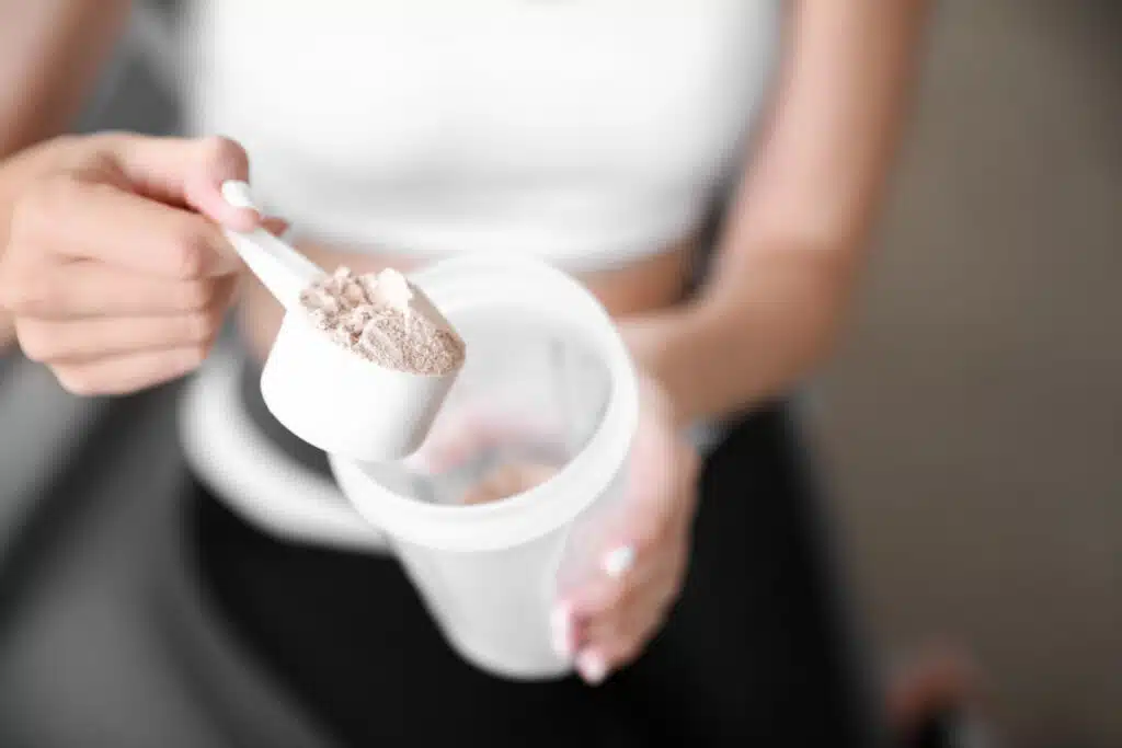 Woman scooping powder into shaker bottle, representing the XTEND workout powders settlement.
