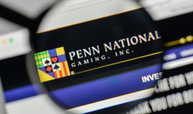 Magnifying glass looking at Penn National Gaming Inc. website representing the Missouri gaming tip pooling settlement.