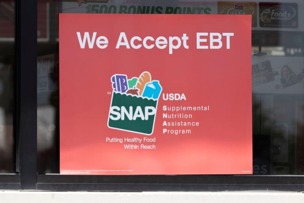 A sign that reads "We accept EBT" on store window