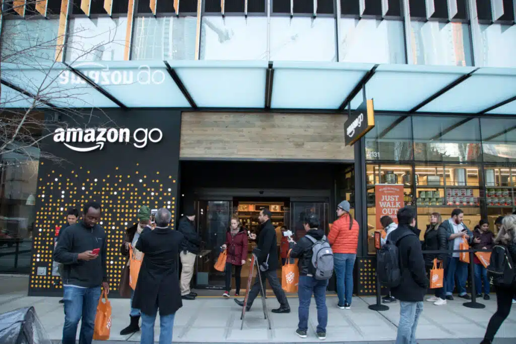 People wait outside an Amazon Go Store, representing the Amazon Go class action.