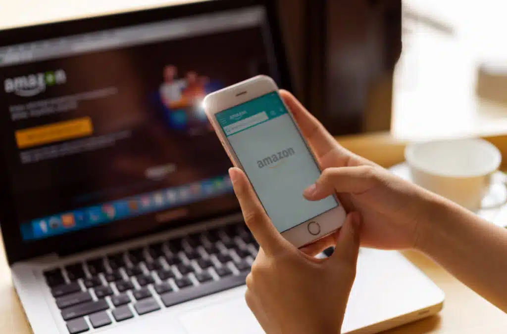 Amazon logo on cellphone with the Amazon homepage in background, representing the Amazon texts class action