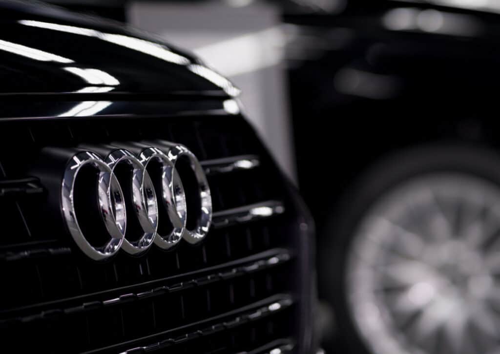 An Audi emblem on the front grill of a vehicle, representing the Audi gateway control module class action lawsuit settlement.