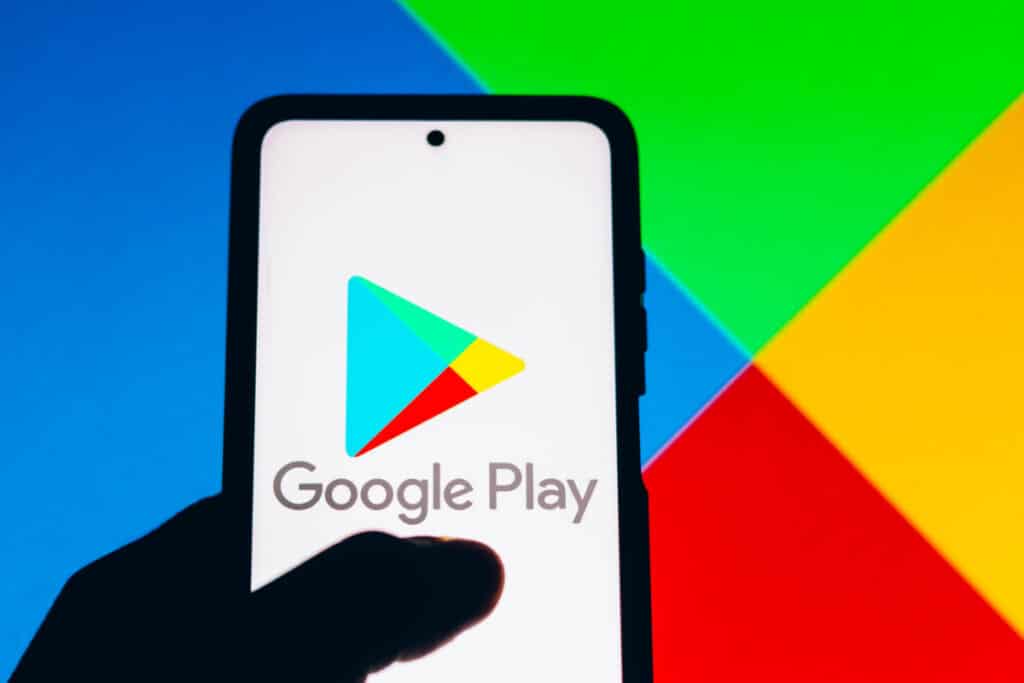 Google play logo on cellphone representing the Google Play app developer class action lawsuit settlement.