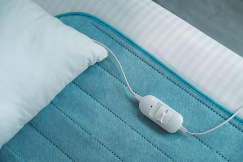 Heated blanket pad on bed with pillow