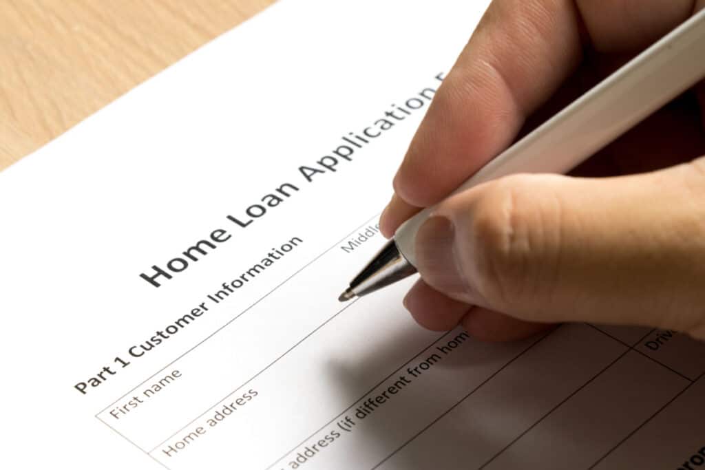 a person filing out a home loan application, representing the SoFi settlement.