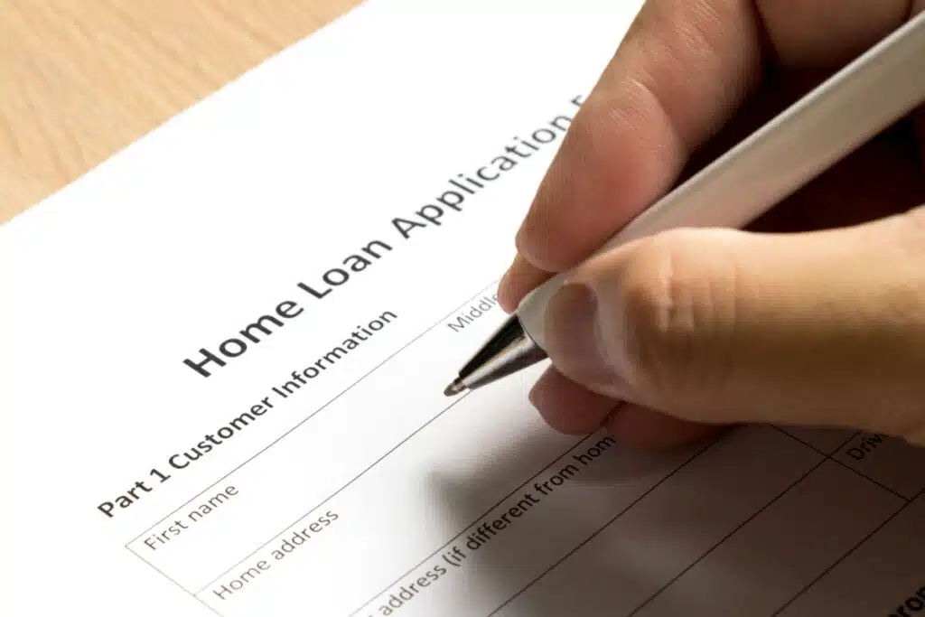 a person filing out a home loan application, representing the SoFi settlement.