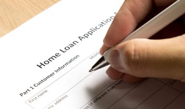 a person filing out a home loan application, representing the SoFi settlement.