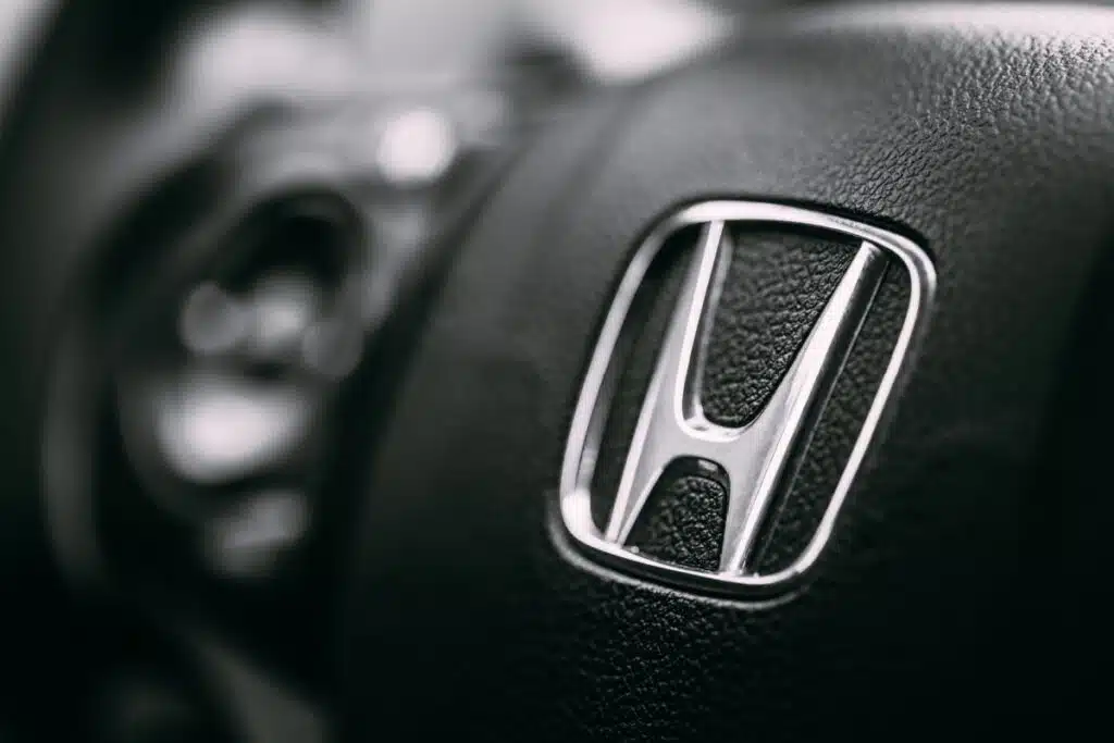 Close up shot of Honda logo on steering wheel, representing the Honda seat belt recall.