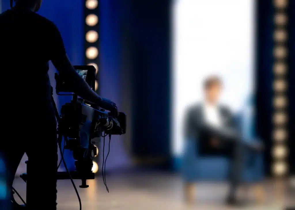 Blurred out man hosting a show representing the Frank Speech class action lawsuit settlement.