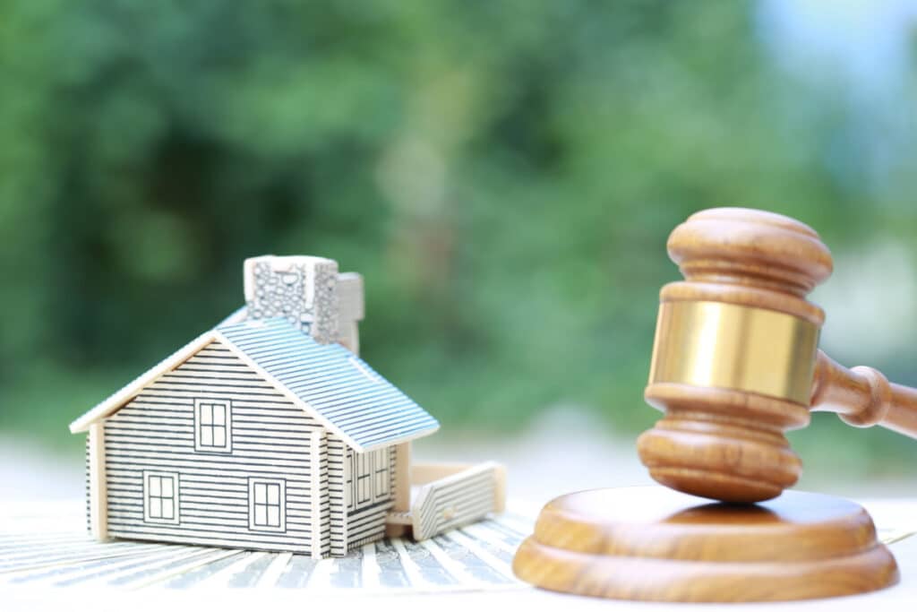 A small house next to a gavel, representing the Indianapolis Housing Authority data breach class action