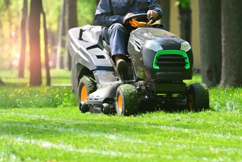 A man riding a riding lawn mower.