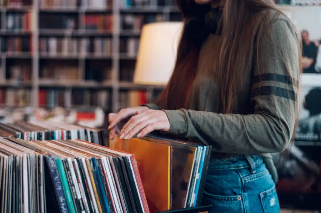 Woman looking through records at records store.