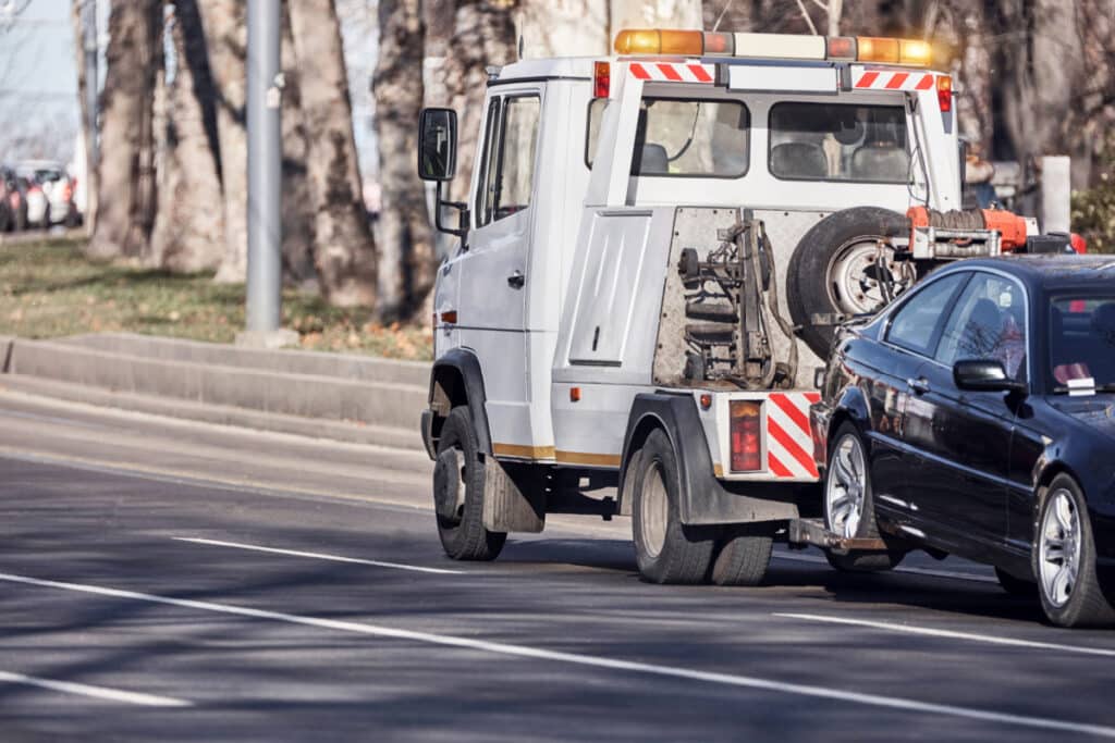 A tow truck repossessing West-Aircomm Federal Credit Union settlement a car representing the