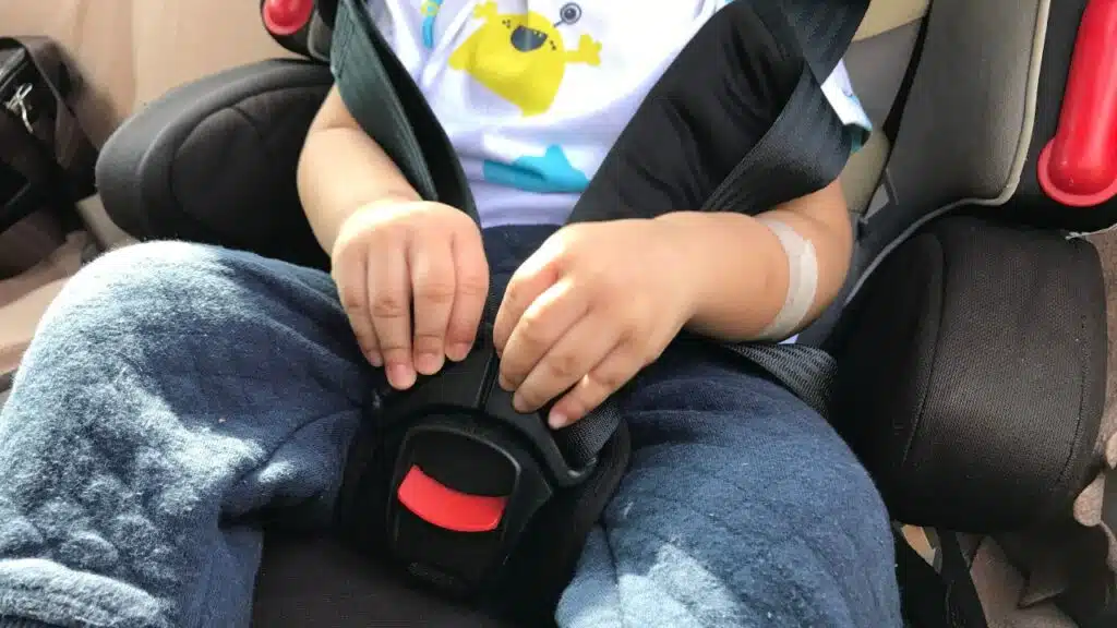 Young child on safety car seat booster