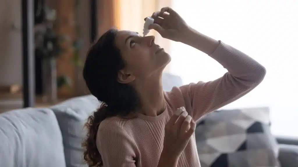 woman putting in eye drops.