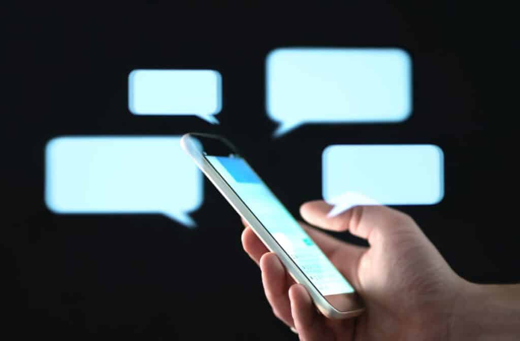 Person holding cell phone with text message bubbles