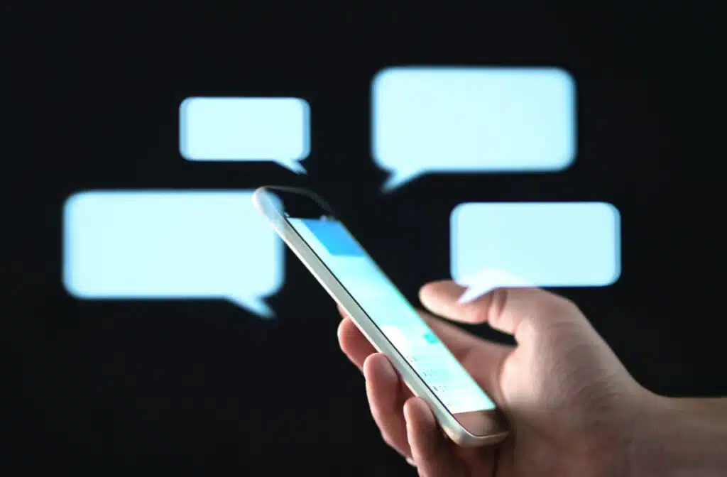 Person holding cell phone with text message bubbles