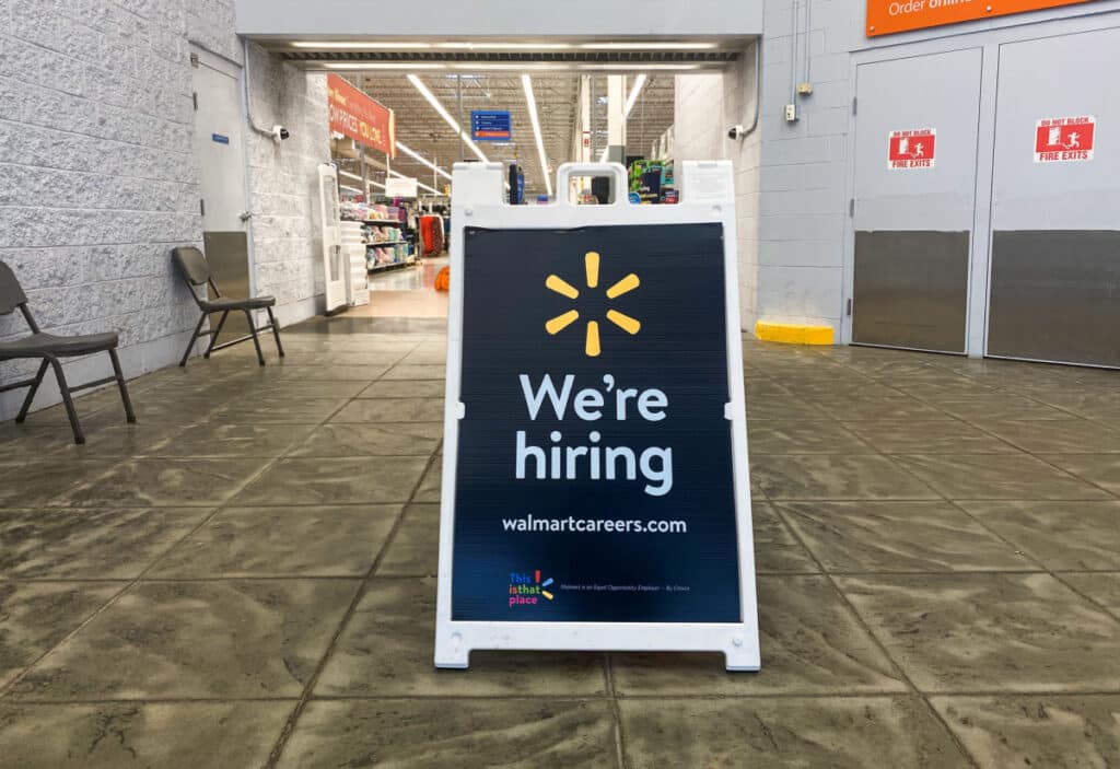 Sign in at front door of Walmart reading "We're Hiring"