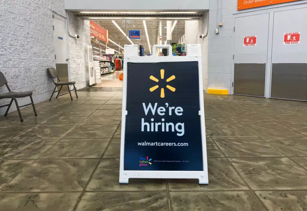 Sign in at front door of Walmart reading "We're Hiring"
