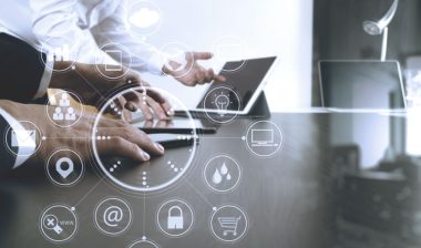 Businessman using mobile phone and digital tablet and laptop representing the Alacrity Solutions Group settlement.