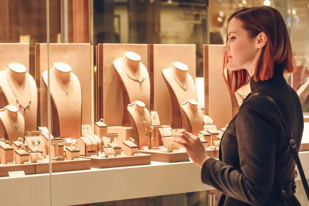 Pretty woman looking at jewelry in store window representing the Don Roberto Jewelers data breach settlement.