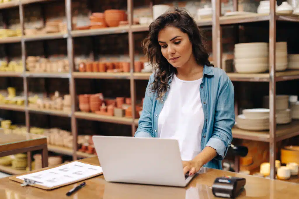 A woman working on a computer at a pottery shop