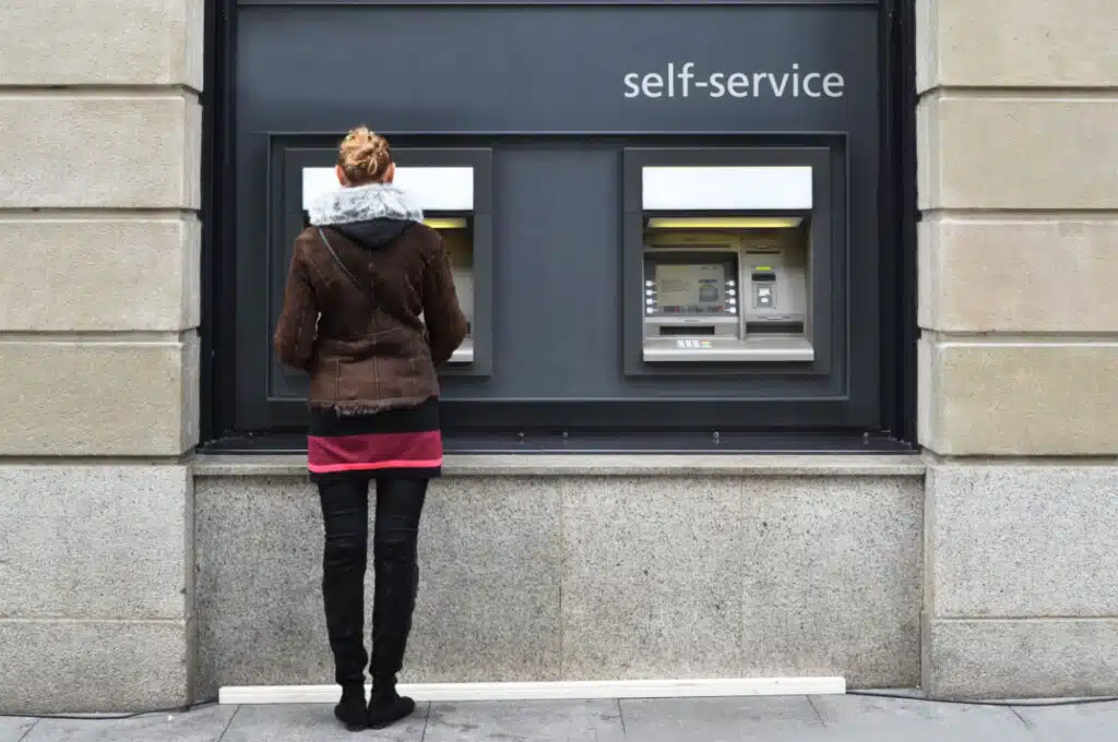 Girl at ATM representing the Public Employees Credit Union settlement.