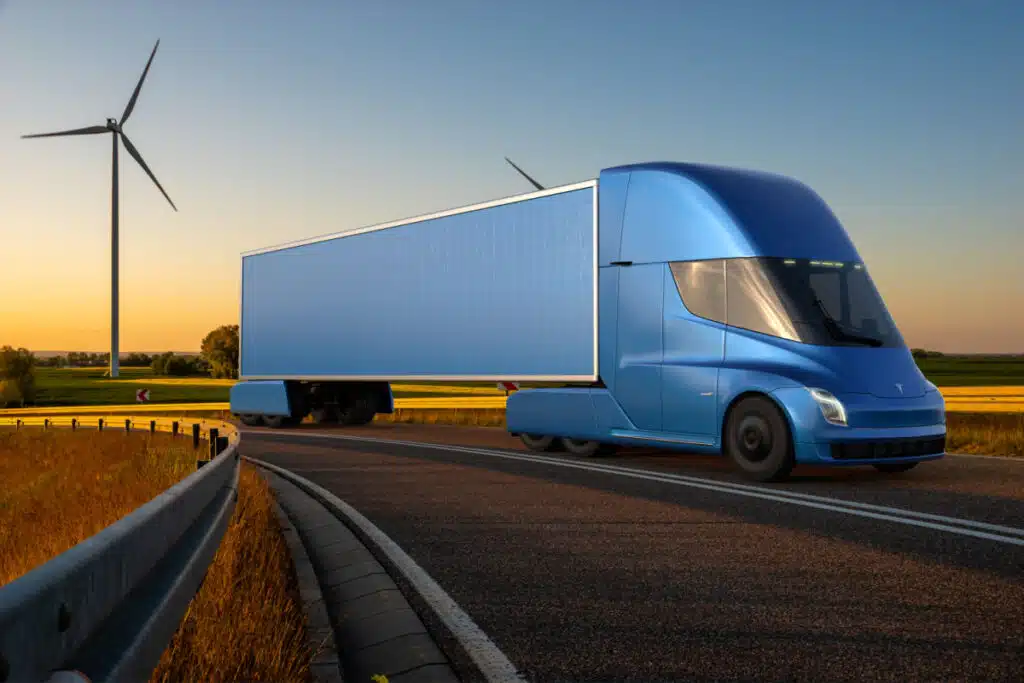 Tesla semi truck driving down road at dusk.