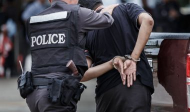 Police arresting a man representing the District of Columbia discriminatory arrests settlement.