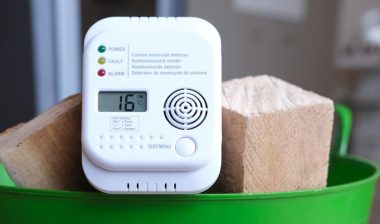 Detail shot of a carbon monoxide alarm or CO warning device in a basket of firewood